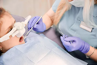 child asleep during dental procedure thanks to pediatric sedation at Bishop Arts Kids