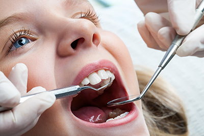 pediatric patient getting her teeth checked on after a root canal at Bishop Arts Kids