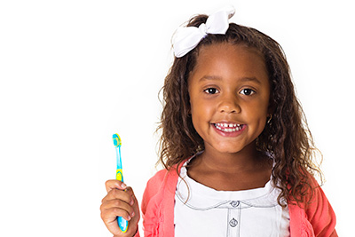 little girl smiling with her toothbrush in her hand