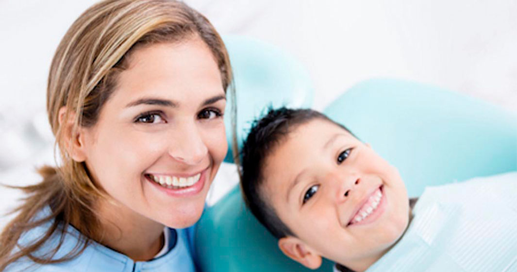 young boy smiling with his dentist during his appointment