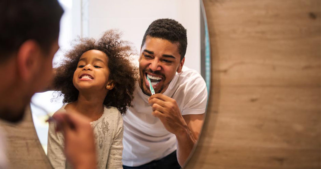 father and son brushing their teeth before bed
